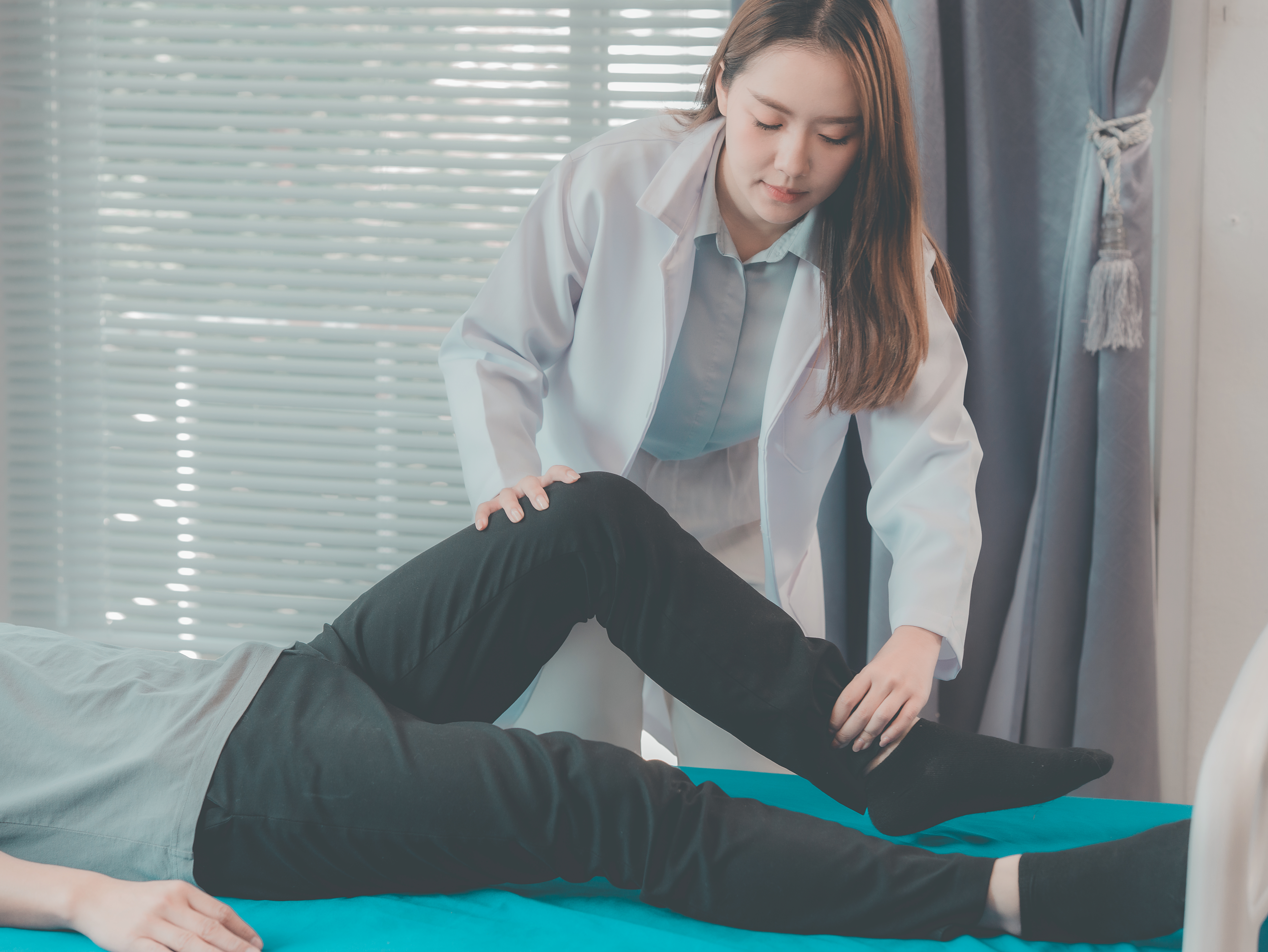 The doctor is performing physical therapy on a male patient who is lying in bed. The doctor has diagnosed a foot injury and is providing physical therapy and rehabilitation.